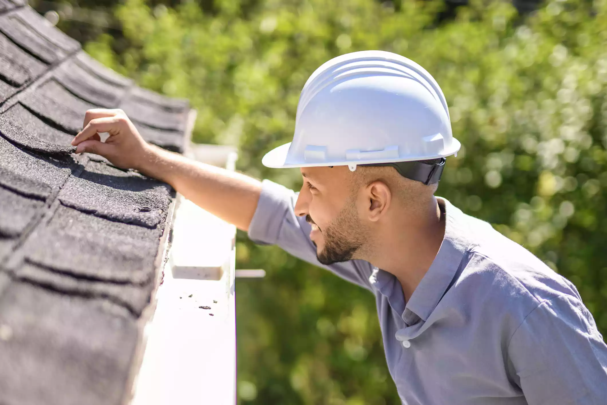 Roofing contractor inspecting storm-damaged shingles in Ohio